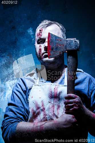 Image of Bloody Halloween theme: crazy killer as butcher with an ax