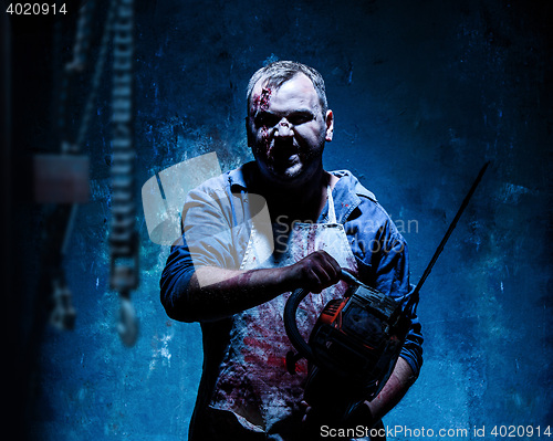 Image of Bloody Halloween theme: crazy killer as butcher with electric saw