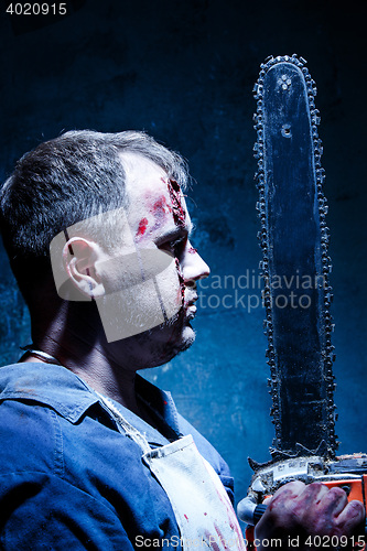 Image of Bloody Halloween theme: crazy killer as butcher with electric saw