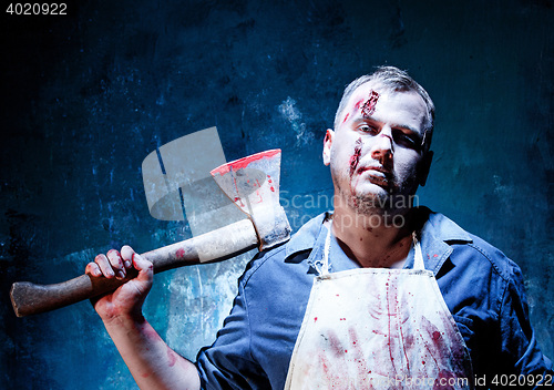 Image of Bloody Halloween theme: crazy killer as butcher with an ax