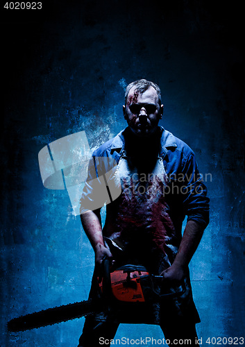 Image of Bloody Halloween theme: crazy killer as butcher with electric saw