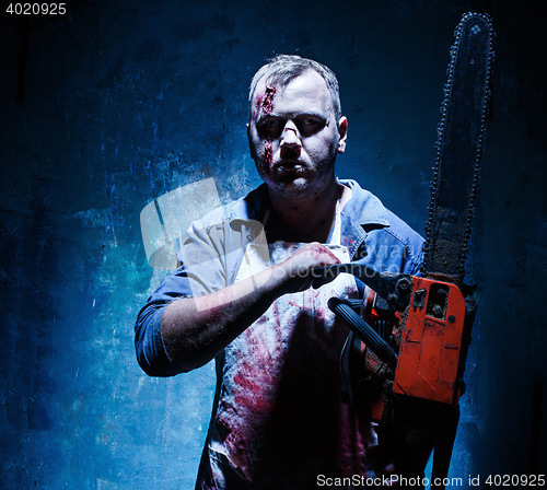 Image of Bloody Halloween theme: crazy killer as butcher with electric saw