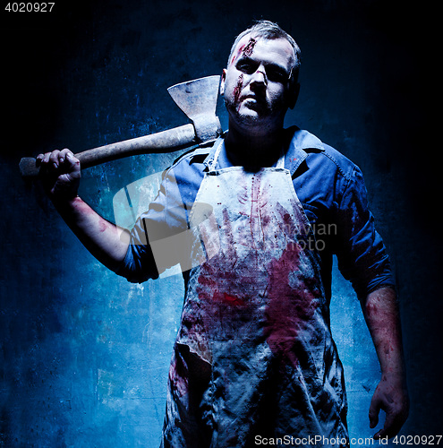 Image of Bloody Halloween theme: crazy killer as butcher with an ax