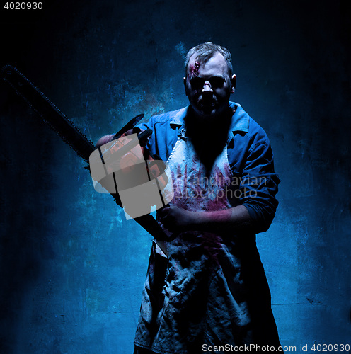 Image of Bloody Halloween theme: crazy killer as butcher with electric saw