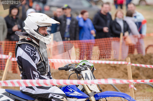 Image of Volgograd, Russia - April 19, 2015: Motorcycle racer smiles before the start of the competition, at the stage of the Open Championship Motorcycle Cross Country Cup Volgograd Region Governor