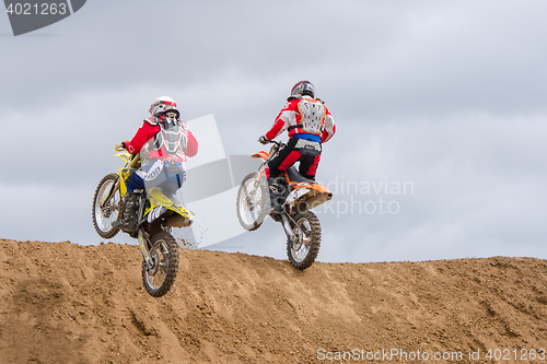 Image of Volgograd, Russia - April 19, 2015: Two motorcycle racer climb onto the next obstacle on the stage of the Open Championship Motorcycle Cross Country Cup Volgograd Region Governor