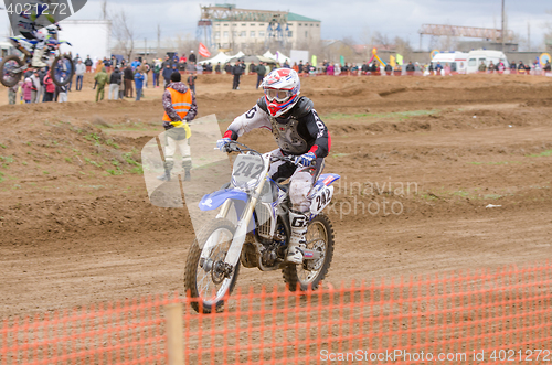 Image of Volgograd, Russia - April 19, 2015: Motorcycle racer racing on the track, the spectators in the background, at the stage of the Open Championship Motorcycle Cross Country Cup Volgograd Region Governor