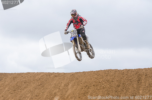 Image of Volgograd, Russia - April 19, 2015: Motorcycle racer jumps a hill, at the stage of the Open Championship Motorcycle Cross Country Cup Volgograd Region Governor