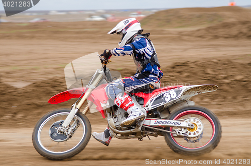 Image of Volgograd, Russia - April 19, 2015: Motorcycle racer rides on the road getting ready to make a turn on the stage of the Open Championship Motorcycle Cross Country Cup Volgograd Region Governor