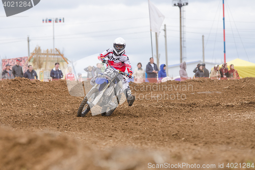 Image of Volgograd, Russia - April 19, 2015: Motorcycle racer insured against falling outstretched leg in the corner, at the stage of the Open Championship Motorcycle Cross Country Cup Volgograd Region Governo