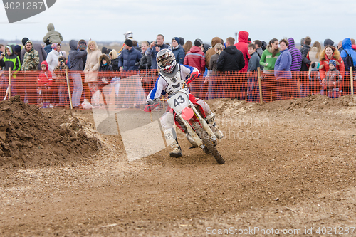 Image of Volgograd, Russia - April 19, 2015: Motorcycle racer rides on the turn track, the spectators in the background, at the stage of the Open Championship Motorcycle Cross Country Cup Volgograd Region Gove