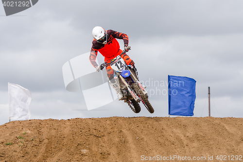 Image of Volgograd, Russia - April 19, 2015: Motorcycle racer jumped out from behind the next hill on the road, on the stage of the Open Championship Motorcycle Cross Country Cup Volgograd Region Governor