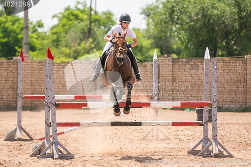 Image of Volgograd, Russia - June 19, 2016: Rider on a horse jumping over the barrier at the jumping competition