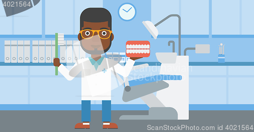 Image of Dentist with dental jaw model and toothbrush.