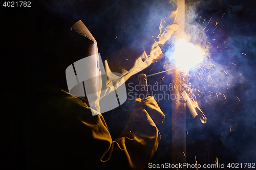 Image of welder worker welding metal by electrode