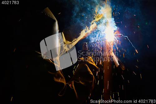 Image of welder worker welding metal by electrode