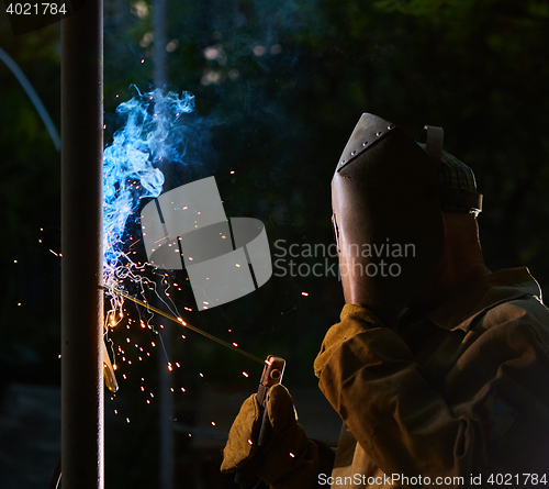 Image of welder worker welding metal by electrode