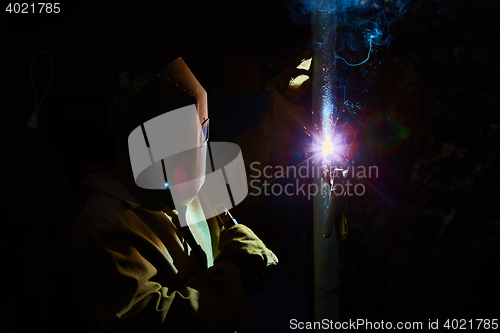 Image of welder worker welding metal by electrode