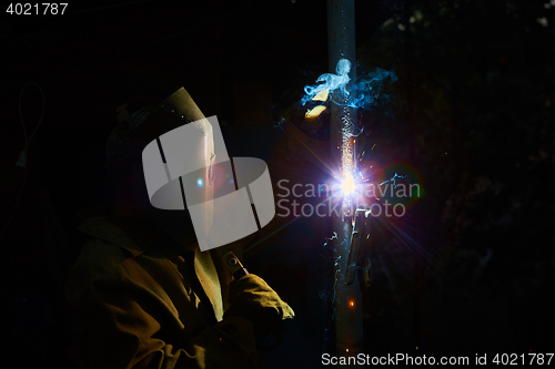 Image of welder worker welding metal by electrode