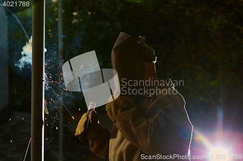 Image of welder worker welding metal by electrode