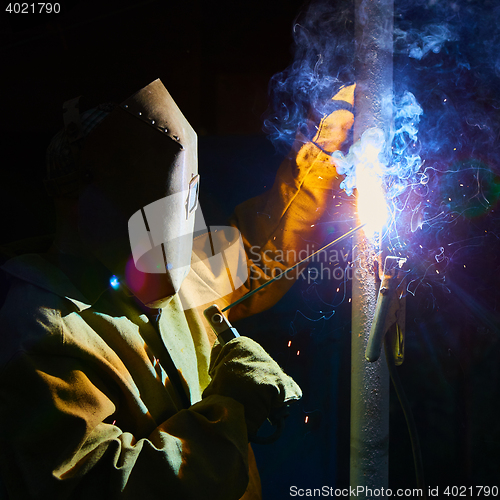 Image of welder worker welding metal by electrode