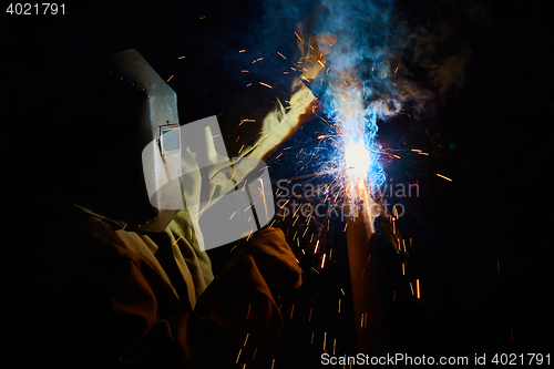 Image of welder worker welding metal by electrode