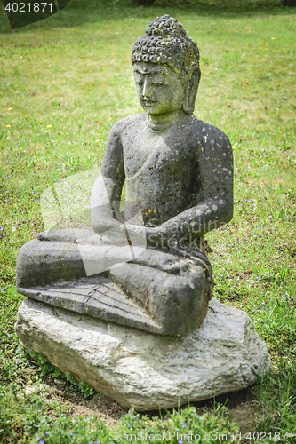 Image of Stone buddha on meadow
