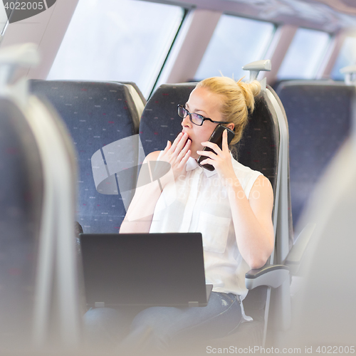 Image of Business woman working while travelling by train.