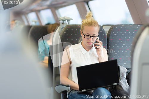 Image of Business woman working while travelling by train.
