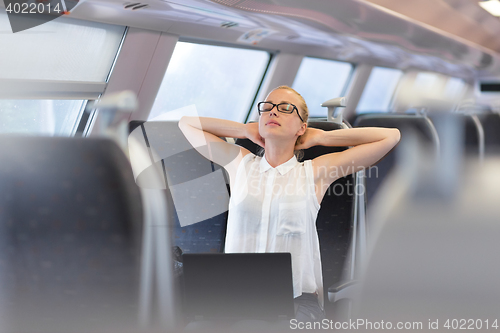 Image of Woman streching while travelling by train.