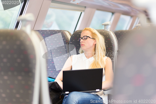 Image of Woman sleeping while travelling by train.