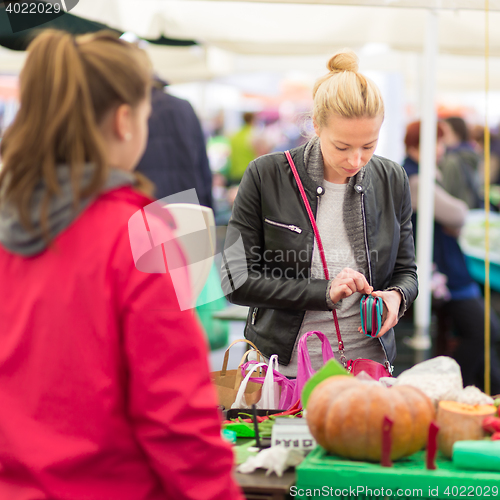 Image of Woman buying vegetable at local food market. 