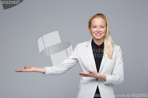 Image of Business woman showing hand sign to side.