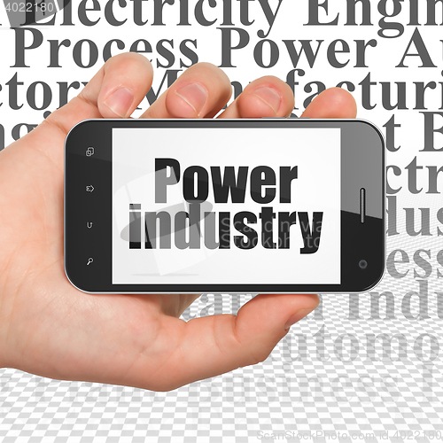 Image of Manufacuring concept: Hand Holding Smartphone with Power Industry on display
