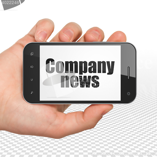 Image of News concept: Hand Holding Smartphone with Company News on display