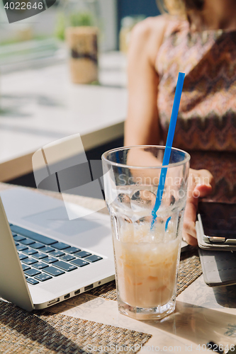 Image of Defocused woman using tablet in cafe