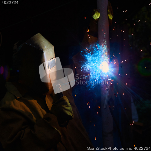 Image of welder worker welding metal by electrode