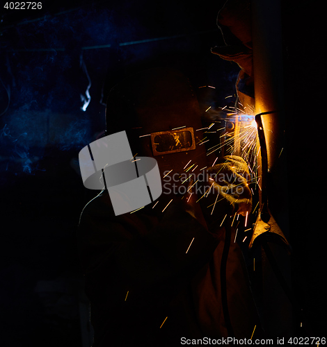 Image of welder worker welding metal by electrode