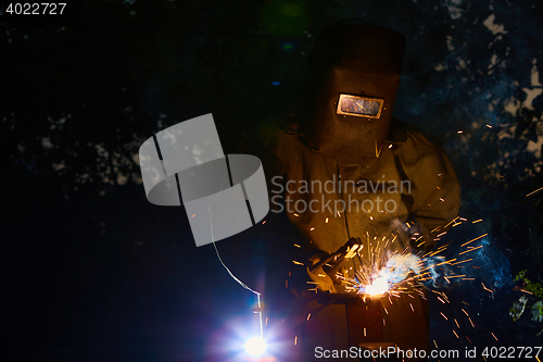 Image of welder worker welding metal by electrode