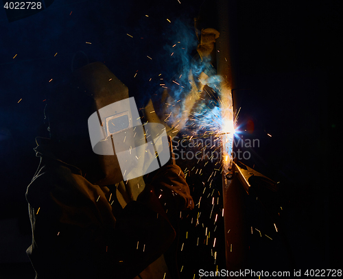 Image of welder worker welding metal by electrode