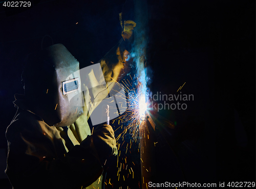 Image of welder worker welding metal by electrode