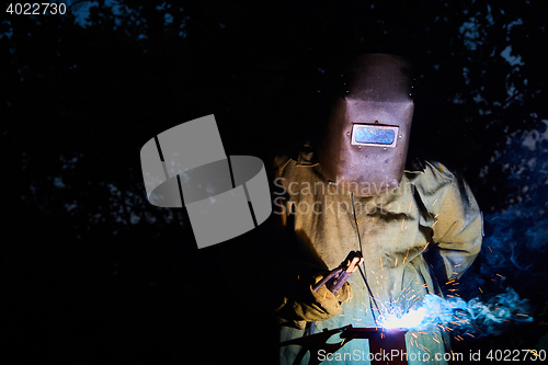 Image of welder worker welding metal by electrode