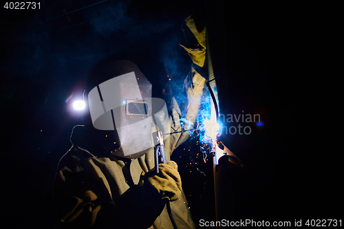 Image of welder worker welding metal by electrode