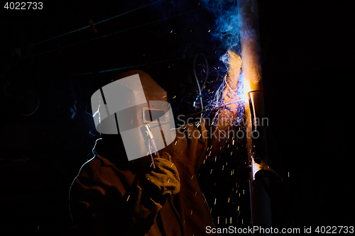 Image of welder worker welding metal by electrode