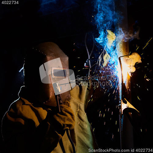 Image of welder worker welding metal by electrode