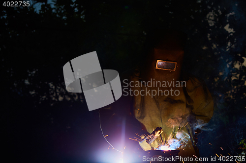 Image of welder worker welding metal by electrode