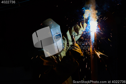 Image of welder worker welding metal by electrode