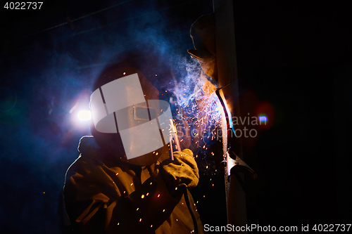 Image of welder worker welding metal by electrode