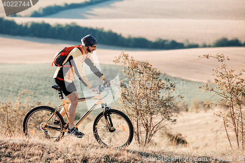 Image of Mountain Bike cyclist riding single track above sunset valley