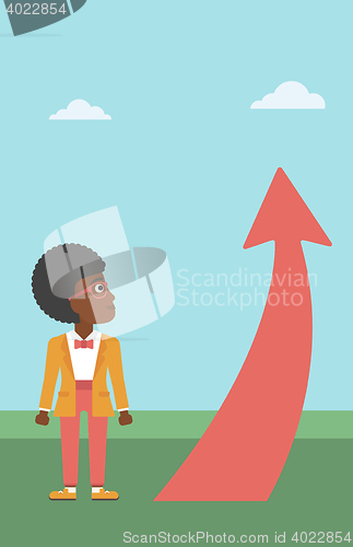 Image of Business woman looking at arrow going up.